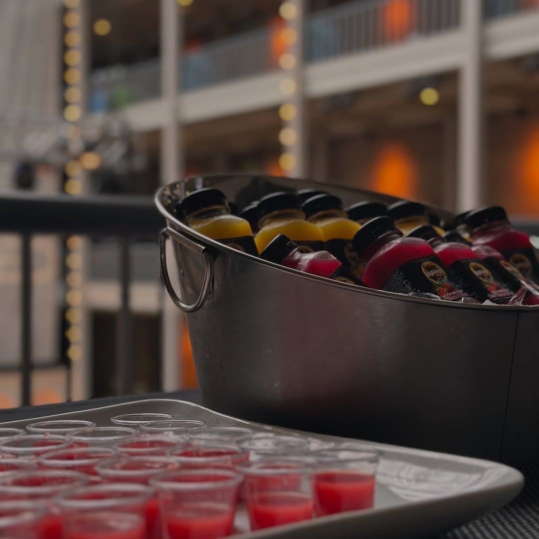 Cold-pressed juice bottles chilled in an ice bucket beside tasting samples